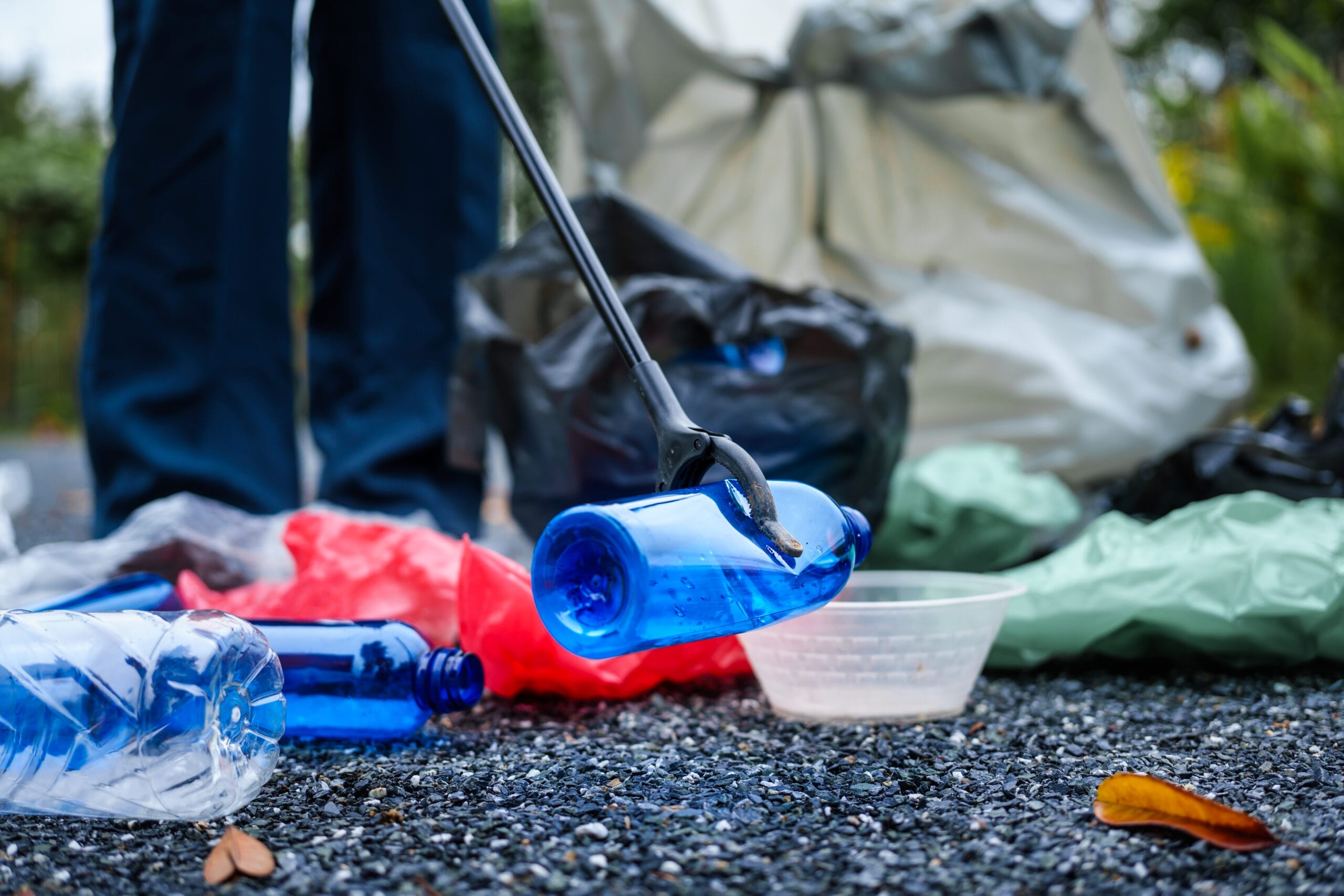 Hands of young women sorting recyclable plastic bottles into trash bags outdoors, related to tear gas cleanup Dallas.