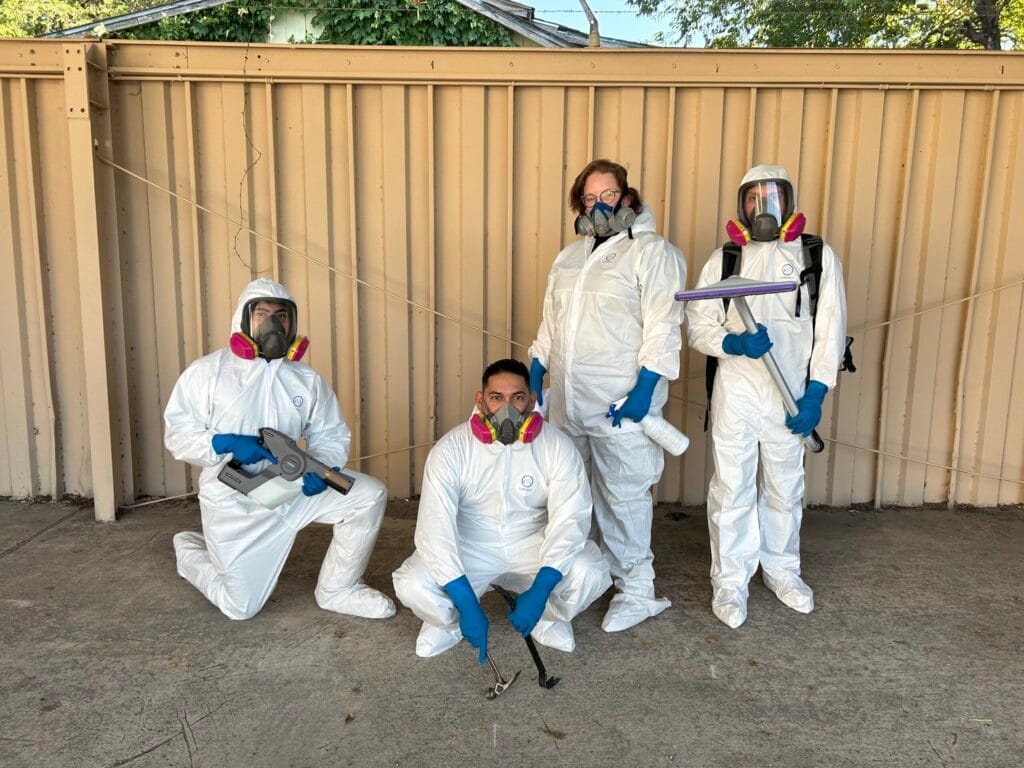 Technician in protective gear performing certified blood cleanup Dallas, handling biohazard materials safely.
