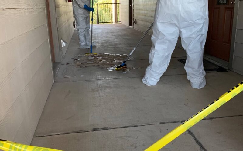 Technicians in protective gear performing certified blood cleanup Dallas in a residential setting, ensuring safety and s